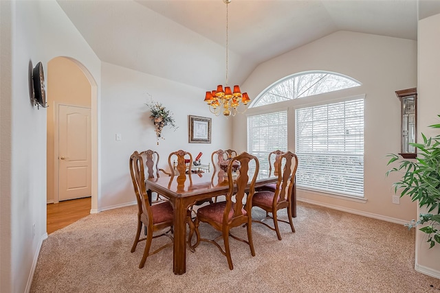 dining room featuring baseboards, light colored carpet, lofted ceiling, an inviting chandelier, and arched walkways