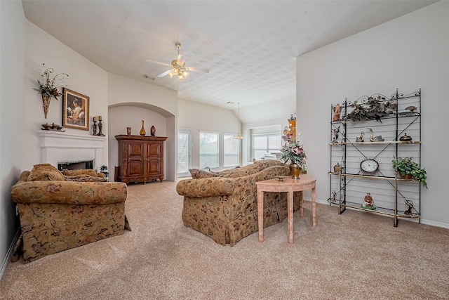 living area with visible vents, carpet floors, a fireplace, ceiling fan, and a textured ceiling