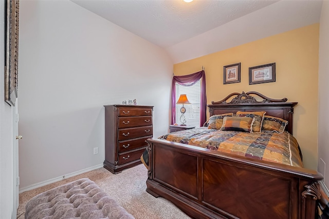 bedroom with vaulted ceiling, baseboards, and light carpet