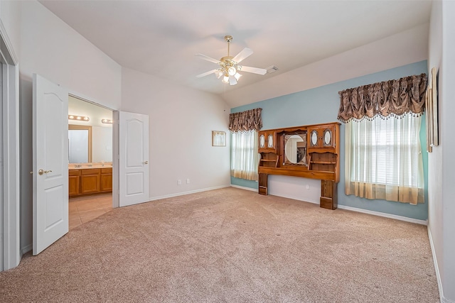 unfurnished bedroom with connected bathroom, baseboards, light colored carpet, and vaulted ceiling