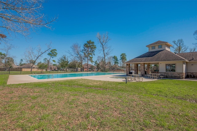 pool featuring a patio area, a lawn, and fence