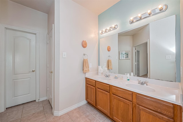 full bathroom with a sink, baseboards, double vanity, and tile patterned flooring