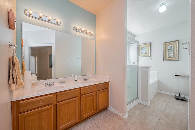 full bathroom with a sink, double vanity, a shower stall, and tile patterned floors