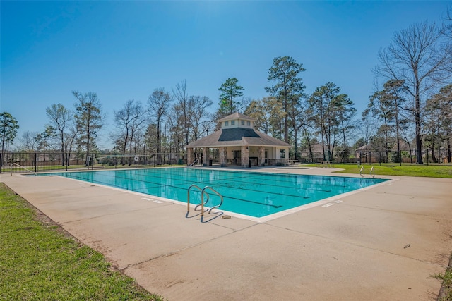 community pool featuring a patio area, a yard, and fence