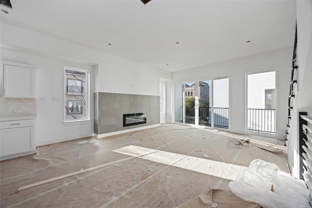 unfurnished living room featuring baseboards and a fireplace