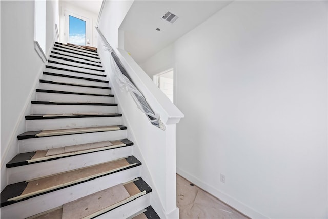 stairway with visible vents and baseboards