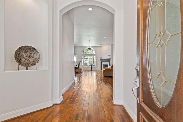 entryway with arched walkways, recessed lighting, baseboards, and hardwood / wood-style flooring