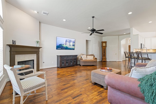 living room with baseboards, recessed lighting, arched walkways, ceiling fan, and hardwood / wood-style flooring