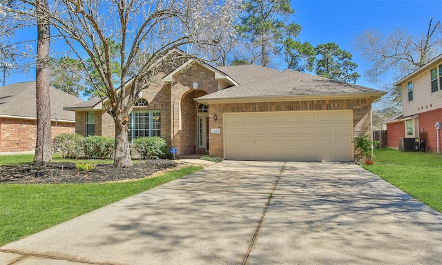 view of front of property with a front lawn, driveway, cooling unit, a garage, and brick siding