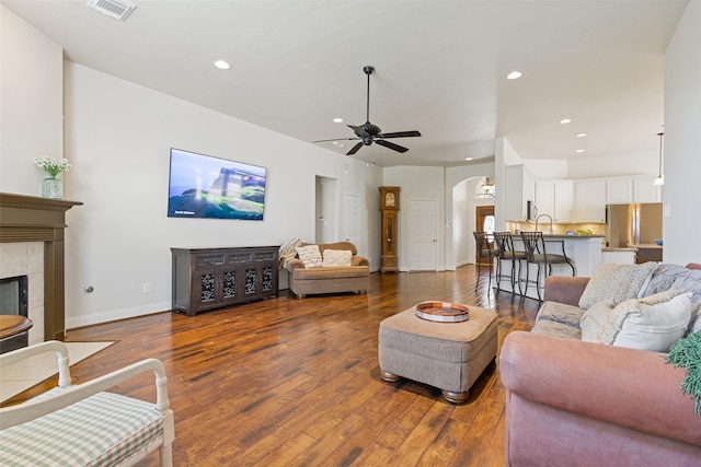 living area featuring visible vents, a ceiling fan, wood finished floors, recessed lighting, and arched walkways