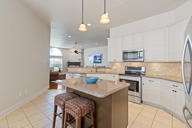 kitchen with a sink, stainless steel appliances, tasteful backsplash, and light tile patterned floors