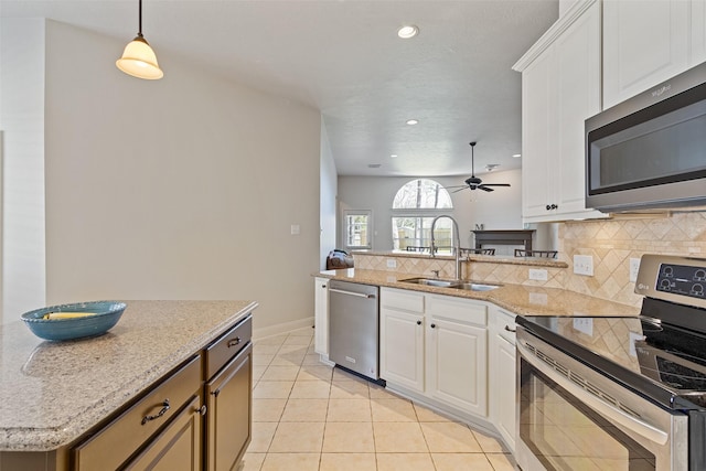 kitchen featuring tasteful backsplash, appliances with stainless steel finishes, ceiling fan, and a sink