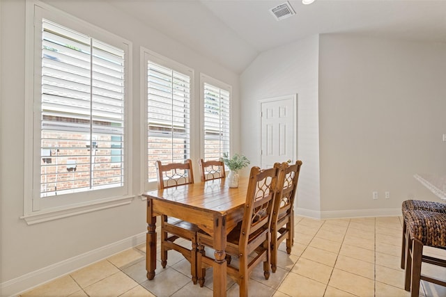 dining room featuring lofted ceiling, light tile patterned flooring, baseboards, and visible vents