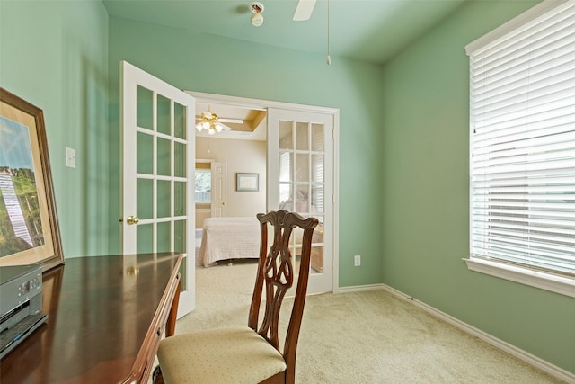 carpeted office space featuring baseboards and ceiling fan