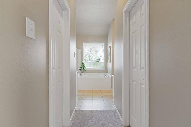 hall with tile patterned flooring and carpet