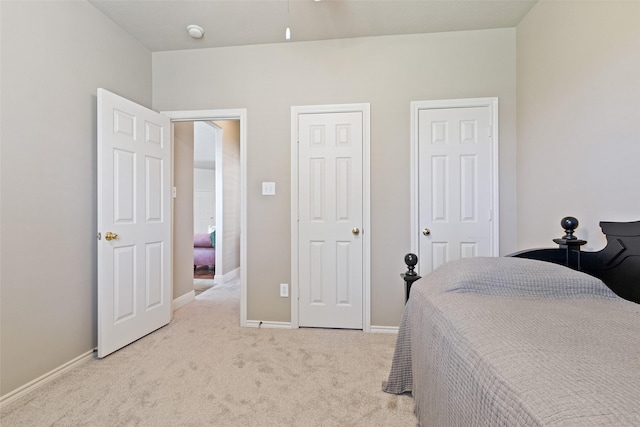 carpeted bedroom with baseboards and multiple closets