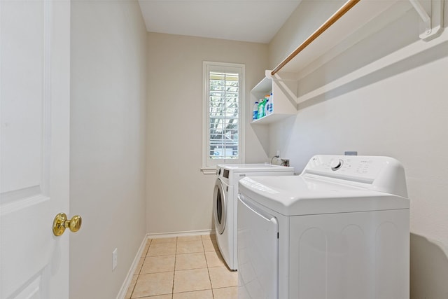 laundry room with laundry area, light tile patterned floors, baseboards, and independent washer and dryer