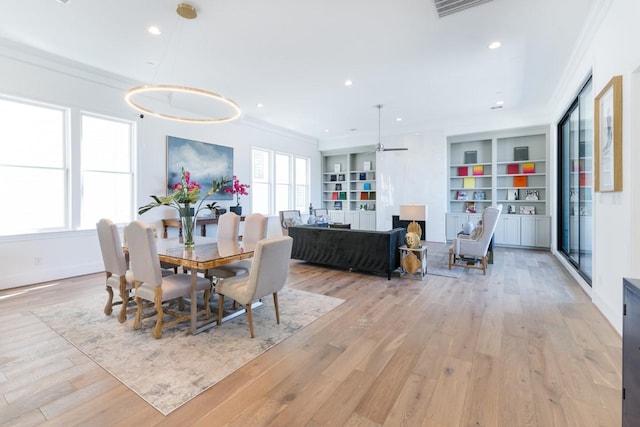 dining room with recessed lighting, built in features, light wood-style flooring, and crown molding