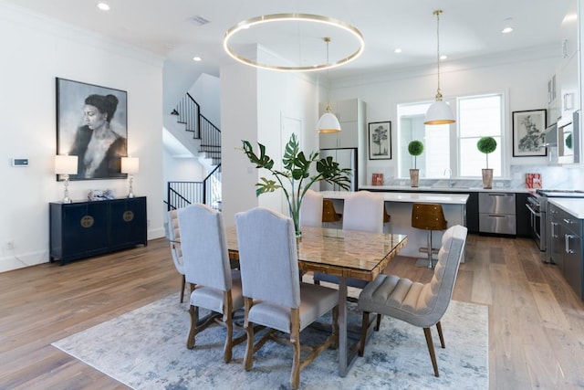 dining space with stairway, recessed lighting, light wood-style floors, and ornamental molding