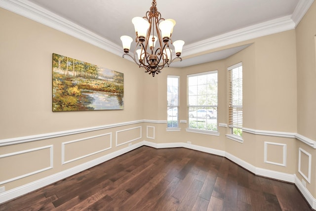 empty room with a decorative wall, a notable chandelier, dark wood-style flooring, and ornamental molding