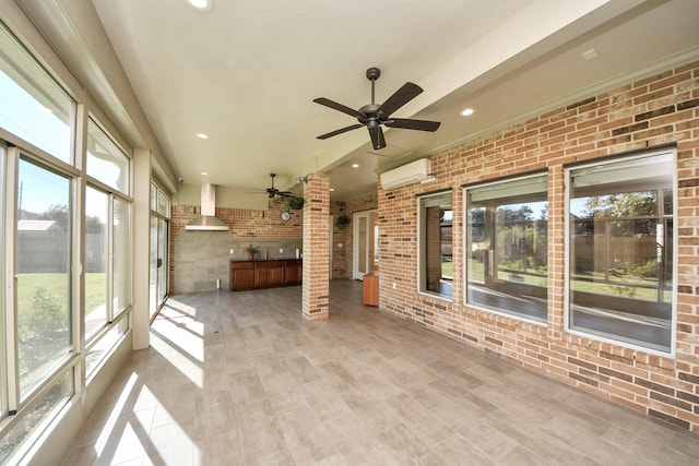 unfurnished sunroom featuring a wall mounted AC, a ceiling fan, and a sink