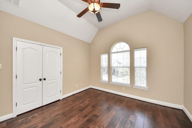 unfurnished bedroom featuring lofted ceiling, baseboards, visible vents, and dark wood-style flooring