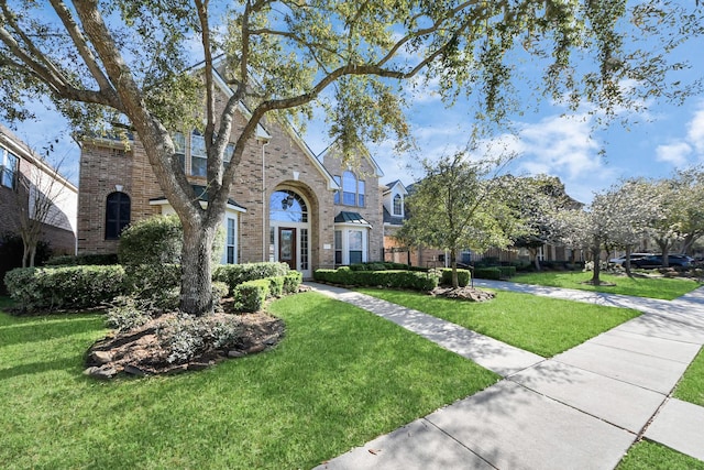 view of front of property with a front lawn and brick siding