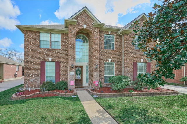 view of front facade featuring brick siding and a front lawn