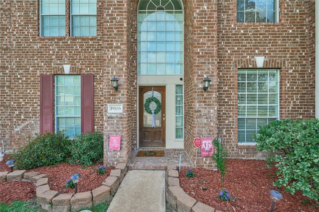 entrance to property featuring brick siding