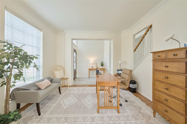 office space with light wood-type flooring, baseboards, and ornamental molding