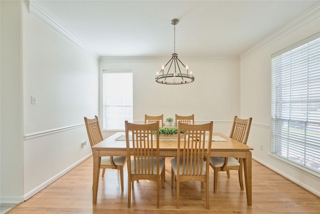 dining room with a chandelier, light wood finished floors, and crown molding