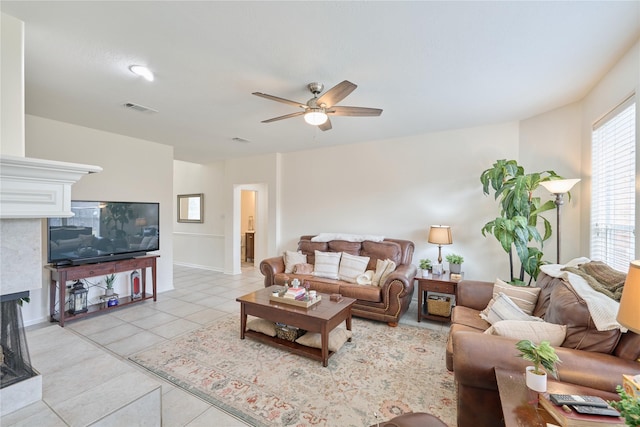 living room with ceiling fan, visible vents, and light tile patterned flooring