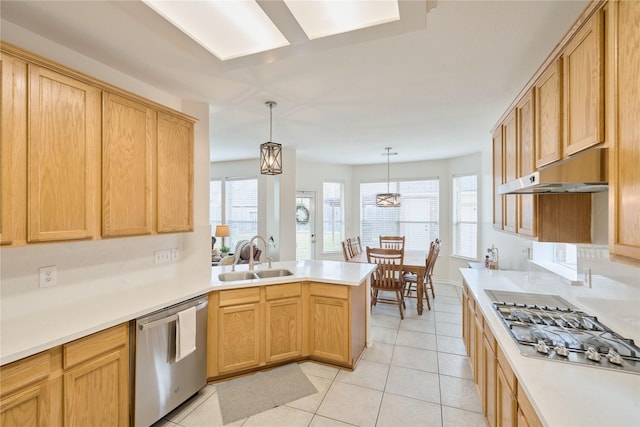 kitchen with light tile patterned floors, a peninsula, a sink, stainless steel appliances, and under cabinet range hood