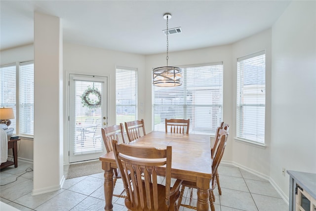 dining area featuring light tile patterned floors, visible vents, a healthy amount of sunlight, and an inviting chandelier