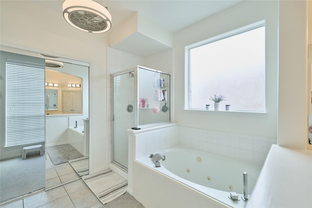 bathroom with tile patterned flooring, a tub with jets, and a stall shower