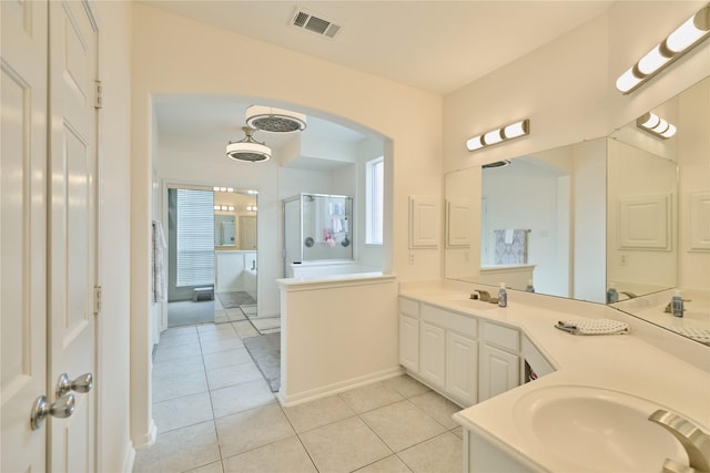 full bath with visible vents, a shower stall, double vanity, tile patterned floors, and a sink