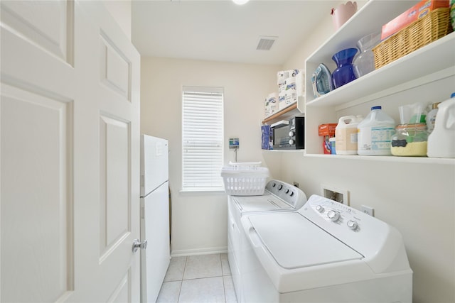 laundry area featuring light tile patterned floors, visible vents, baseboards, laundry area, and separate washer and dryer