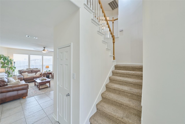 stairway featuring tile patterned floors, a ceiling fan, visible vents, and baseboards