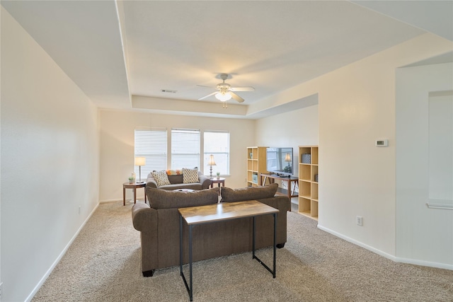 living room featuring visible vents, baseboards, carpet flooring, a raised ceiling, and ceiling fan