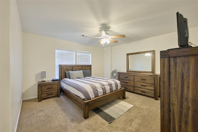 bedroom with a ceiling fan, light colored carpet, visible vents, and baseboards