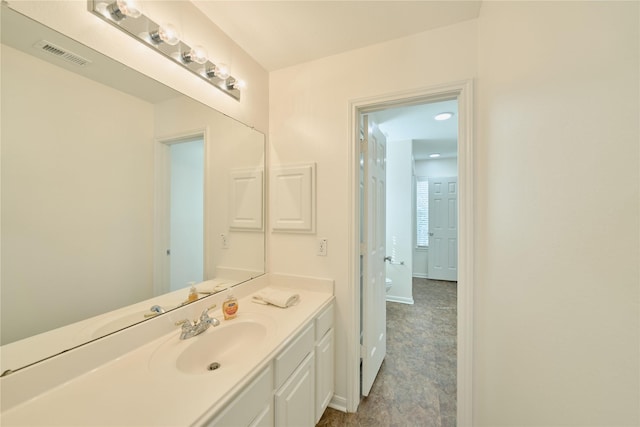 bathroom featuring vanity, toilet, baseboards, and visible vents