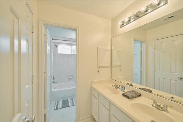 full bathroom with a sink, visible vents, double vanity, and tile patterned flooring