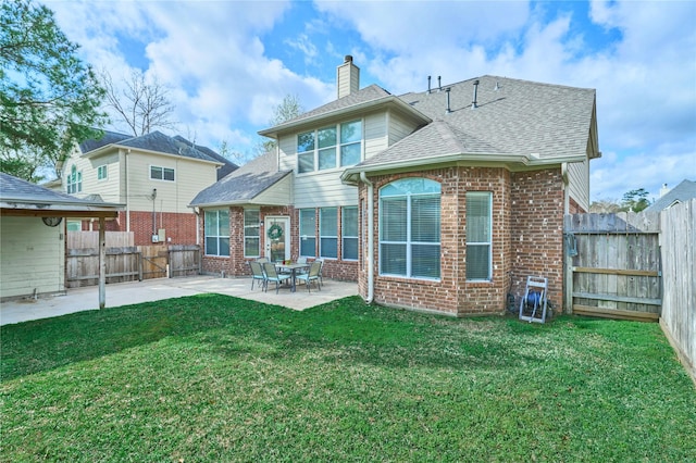 back of house featuring a yard, brick siding, a fenced backyard, and a patio area