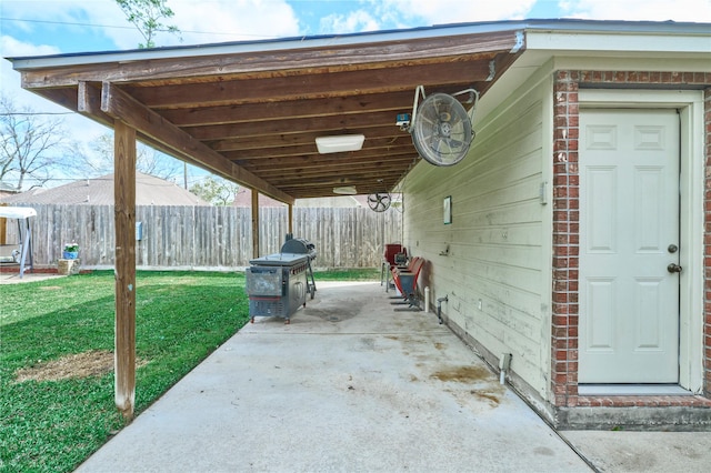 view of patio featuring a carport and fence