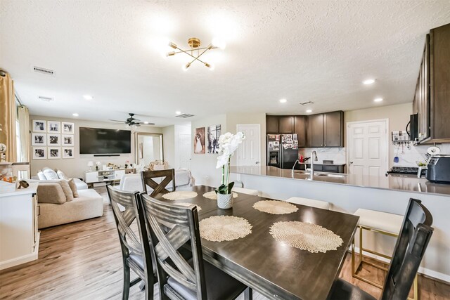 dining room with visible vents, light wood-style flooring, a textured ceiling, recessed lighting, and ceiling fan