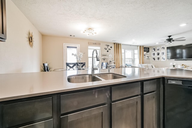 kitchen with open floor plan, light countertops, black dishwasher, a textured ceiling, and a sink