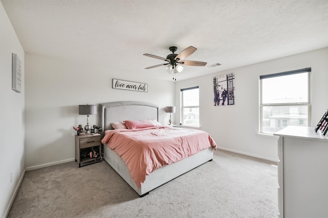 bedroom featuring visible vents, carpet flooring, a textured ceiling, and baseboards