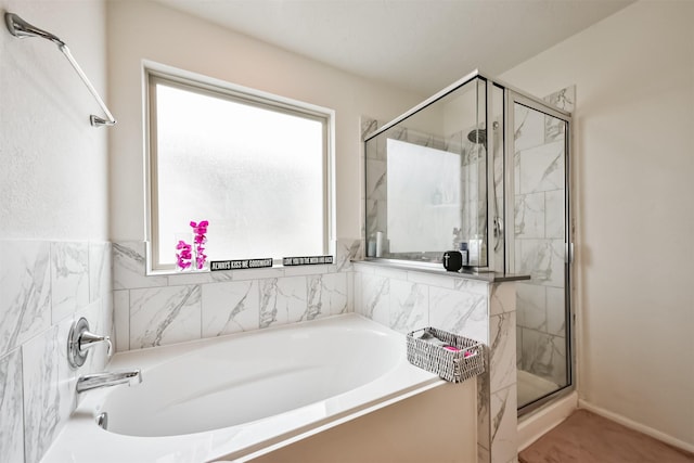 full bathroom featuring a bath and a marble finish shower