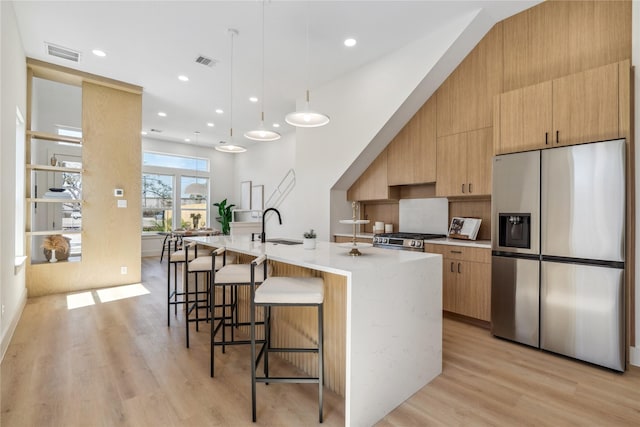 kitchen with a large island, visible vents, stainless steel appliances, and modern cabinets