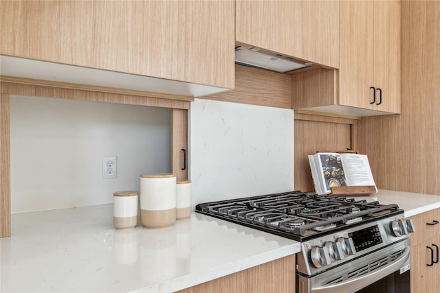 kitchen with light countertops, ventilation hood, light brown cabinets, and stainless steel range with gas cooktop